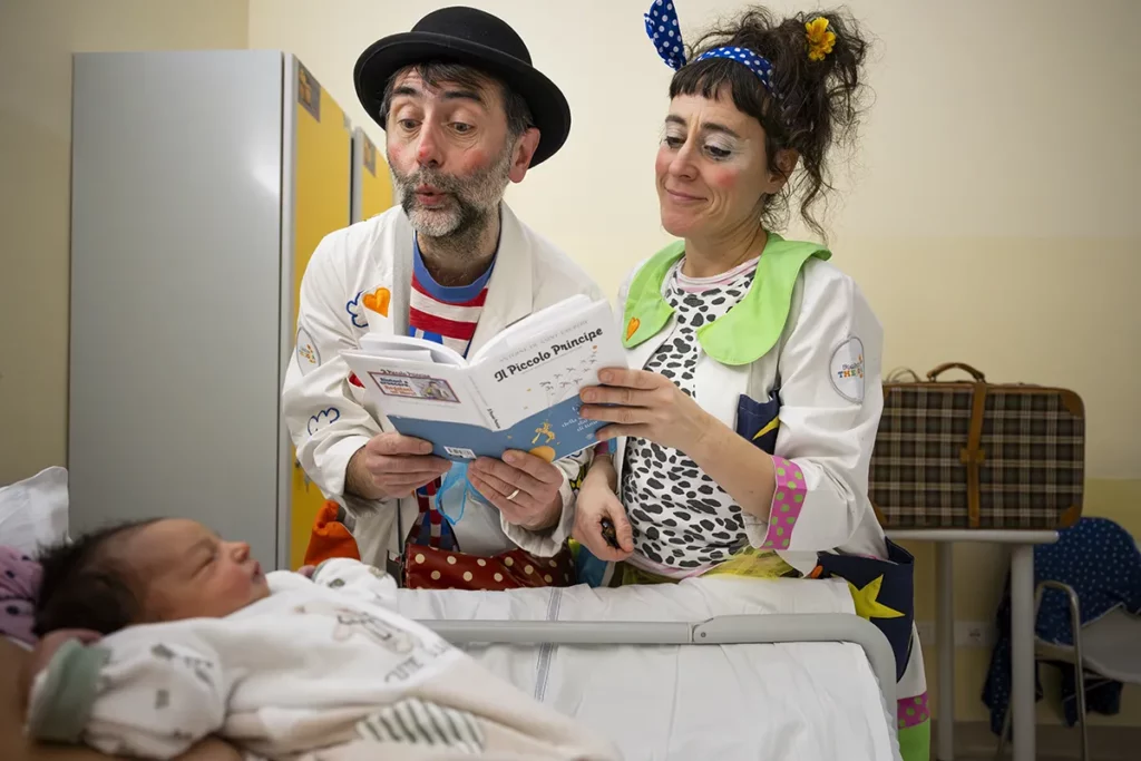 Doctores Sonrisa de la Fundación Theodora leen un cuento junto a la cuna de un bebé