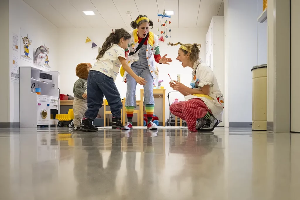 Doctoras Sonrisa de la Fundación Theodora bailan con niños en un pasillo del hospital