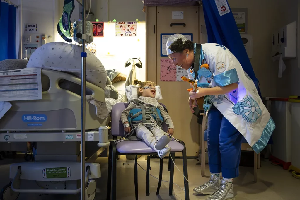 Doctora Sonrisa de la Fundación Theodora visita a una niña en su sillón de tratamiento