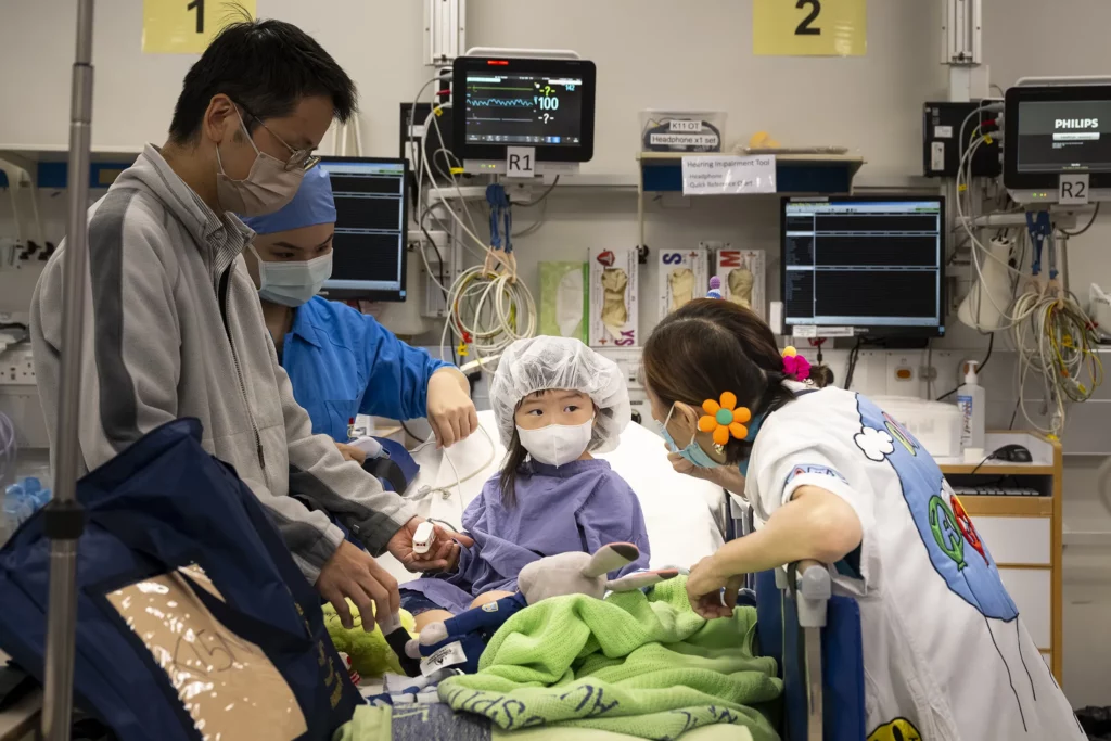 Doctora Sonrisa de la Fundación Theodora acompaña a un niño y su padre en una sala
