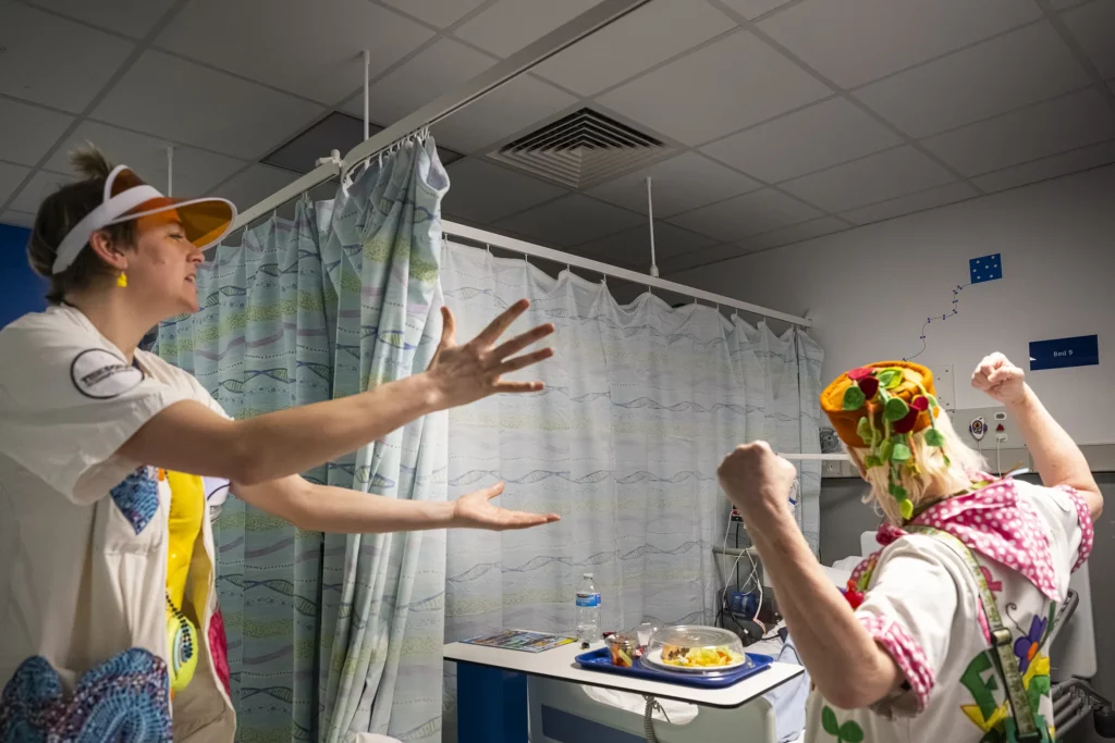 Doctoras Sonrisa de la Fundación Theodora juegan con los brazos abiertos en una habitación
