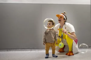 Doctora Sonrisa de la Fundación Theodora hace pompas de jabón para un niño pequeño